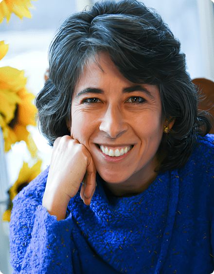 A woman in blue sweater smiling for the camera.